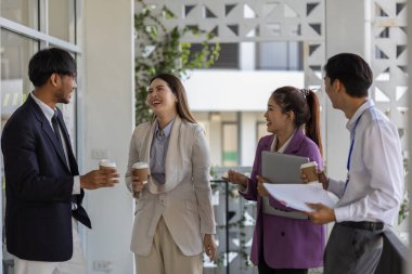 İş adamları şirkette yürürken konuşuyorlar, tüm planlama departmanı personeli toplantıya birlikte yürüyorlar, iş sahipleri ofise yürürken konuşuyorlar.