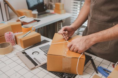 Çalışan, müşterilere nakliyeye hazırlanmak için ürünleri kutulara koyuyor, küçük bir online işletme sahibi müşterilere göndermeden önce doğruluk için kutucukları işaretliyor, paket,