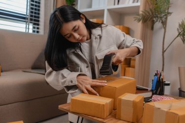 Tüm müşterilere göndermek için paket hazırlıyor. Bu girişimcinin küçük bir işletmesi var. Sme, internetten ürün satıyor.