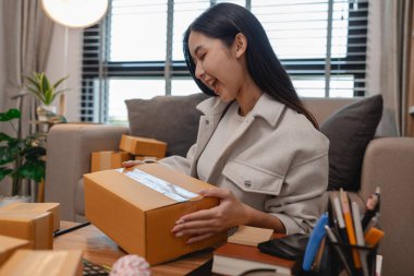 Tüm müşterilere göndermek için paket hazırlıyor. Bu girişimcinin küçük bir işletmesi var. Sme, internetten ürün satıyor.