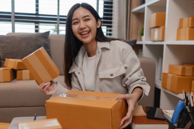 Tüm müşterilere göndermek için paket hazırlıyor. Bu girişimcinin küçük bir işletmesi var. Sme, internetten ürün satıyor.