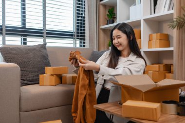 Müşterilere gönderilmek üzere ürünleri memnuniyetle kutulara dolduruyor, bir girişimci alıcılara, paketlere, paketlere, paketlere, küçük işletmelere, hazırlıklara gönderilecek ürünleri hazırlıyor