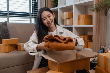 Tüm müşterilere göndermek için paket hazırlıyor. Bu girişimcinin küçük bir işletmesi var. Sme, internetten ürün satıyor.