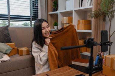 Ürününü çevrimiçi satmak için yaşıyor, sme, o bir girişimci ve küçük bir işletmesi var, canlı yayın, paket, ürünlerini internette satıyor, yaşadığı zaman müşteriyle konuşuyor.