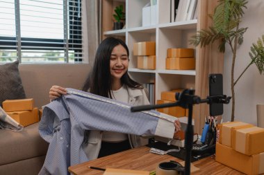 Ürününü çevrimiçi satmak için yaşıyor, sme, o bir girişimci ve küçük bir işletmesi var, canlı yayın, paket, ürünlerini internette satıyor, yaşadığı zaman müşteriyle konuşuyor.