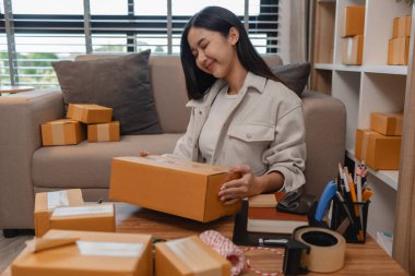 Tüm müşterilere göndermek için paket hazırlıyor. Bu girişimcinin küçük bir işletmesi var. Sme, internetten ürün satıyor.