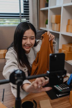 Ürününü çevrimiçi satmak için yaşıyor, sme, o bir girişimci ve küçük bir işletmesi var, canlı yayın, paket, ürünlerini internette satıyor, yaşadığı zaman müşteriyle konuşuyor.