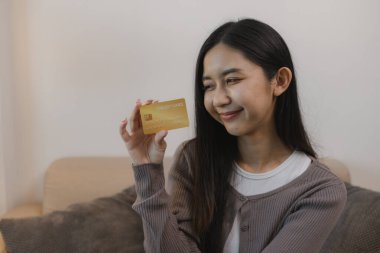 Kredi kartını ödeyerek internetten alışveriş yapmayı seviyor. Banka kartındaki bakiye mutlu bir şekilde harcaması için yeterli. Boş zamanlarını kredi kartıyla alışveriş yaparak geçiriyor.