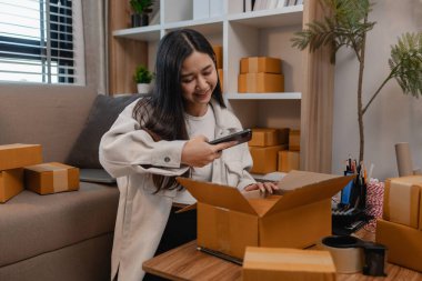 Tüm müşterilere göndermek için paket hazırlıyor. Bu girişimcinin küçük bir işletmesi var. Sme, internetten ürün satıyor.