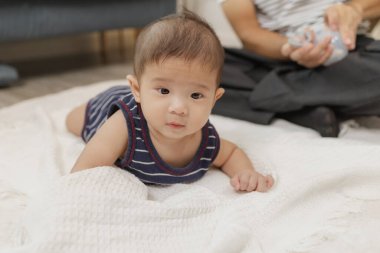 Bir baba bebeğiyle kaliteli zaman geçirir. Yumuşak bir paspasın üzerinde nazik bakım ve eğlenceli anlarda oynayıp bağ kurar. Bebek karın zamanını ve emzik kullanımını destekliyor..