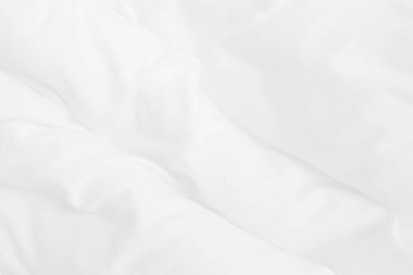 Beyaz battaniye dokusu ve yatak odasında kırışık ya da dağınık yatak örtüsü..