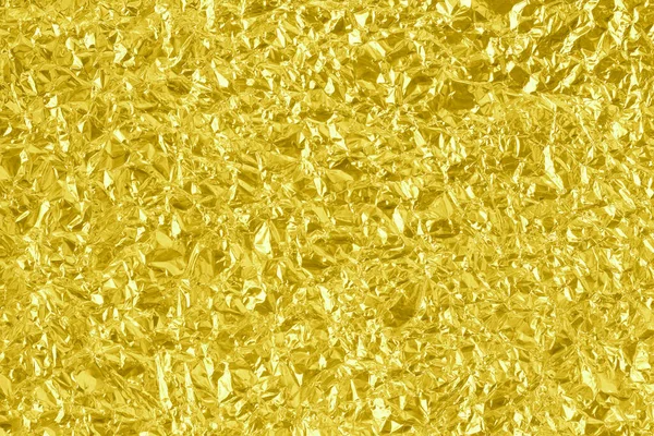 Shiny gold foil texture background, pattern of yellow wrapping paper with crumpled and wavy.