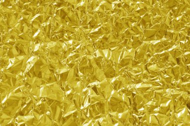 Parlak altın folyo desenli arka plan, buruşuk ve dalgalı sarı ambalaj kağıdı deseni.