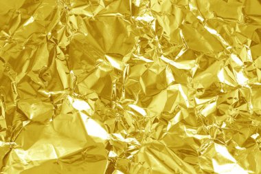 Parlak altın folyo desenli arka plan, buruşuk ve dalgalı sarı ambalaj kağıdı deseni.