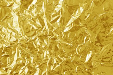 Parlak altın folyo desenli arka plan, buruşuk ve dalgalı sarı ambalaj kağıdı deseni.