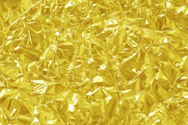 Parlak altın folyo desenli arka plan, buruşuk ve dalgalı sarı ambalaj kağıdı deseni.