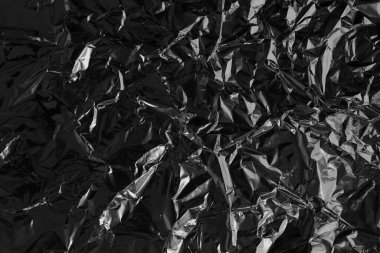 Parlak siyah folyo dokusu, buruşuk ve dalgalı ambalaj kağıdı deseni.