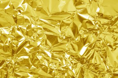 Parlak altın folyo desenli arka plan, buruşuk ve dalgalı sarı ambalaj kağıdı deseni.
