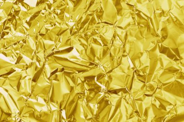Parlak altın folyo desenli arka plan, buruşuk ve dalgalı sarı ambalaj kağıdı deseni.