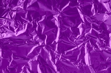 Shiny purple foil texture background, pattern of violet wrapping paper with crumpled and wavy.