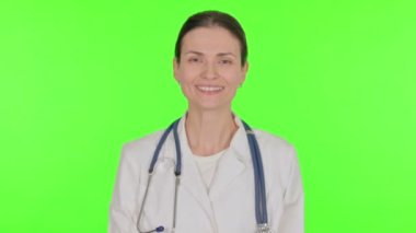 Thumbs Up by Young Female Doctor on Green Background 