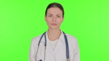 Smiling Young Female Doctor on Green Background 