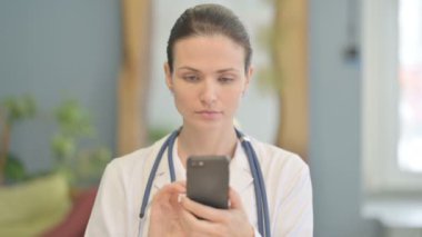 Genç bayan doktor interneti taramak için akıllı telefon kullanıyor