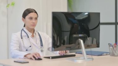 Klinikte Masaüstü Bilgisayarı üzerinde çalışan genç bayan doktor