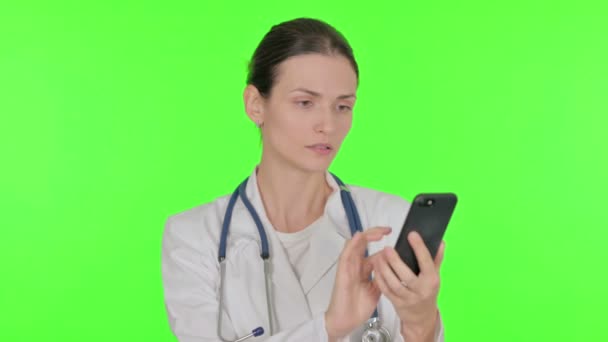 Young Female Doctor Browsing Smartphone Green Background — Stockvideo