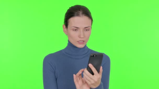 Junge Frau Feiert Auf Grünem Hintergrund Mit Smartphone — Stockvideo