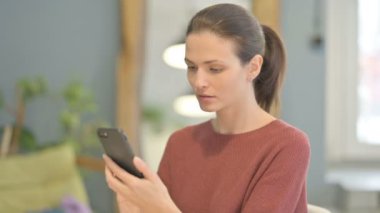 Excited Young Woman Celebrating Win on Smartphone