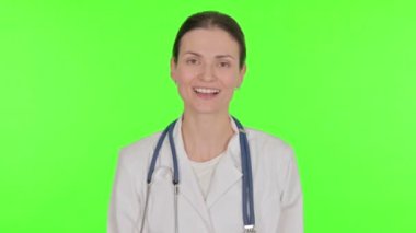 Young Female Doctor Talking on Online Video Call on Green Background 