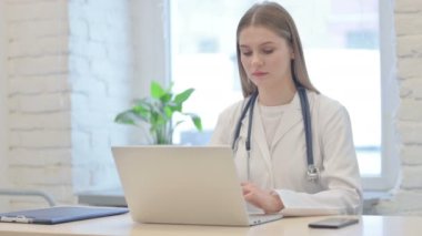 Genç Bayan Doktor Laptop kullanırken kameraya gülümsüyor