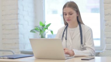 Genç Kadın Doktor Laptop kullanırken Kameraya Bakıyor