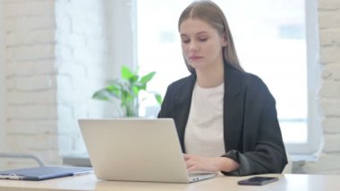 İş kadını Laptop kullanırken kameraya gülümsüyor