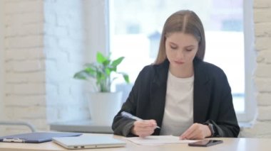Ofiste otururken evrak işi yapan iş kadını