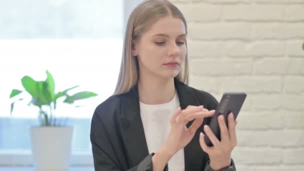 スマートフォンで損失に反応する衝撃的なビジネス女性 — ストック動画