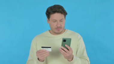 Handsome Young Man Shopping Online on Smartphone on Blue Background