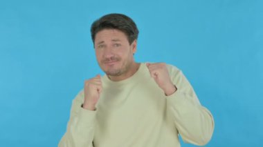 Handsome Young Man Dancing in Joy on Blue Background