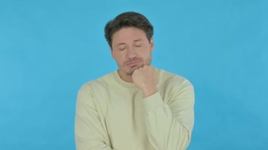 Handsome Young Man Sleeping on Blue Background