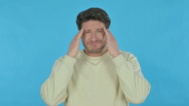 Tense Handsome Young Man with Headache on Blue Background