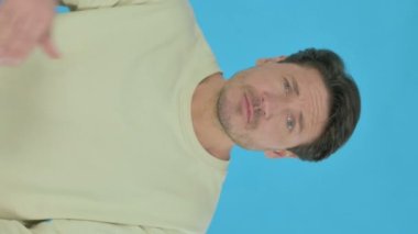 Handsome Young Man Searching Opportunity on Blue Background, Vertical Video