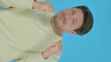 Handsome Young Man Dancing in Joy on Blue Background, Vertical Video