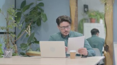 Middle Aged Businessman Working on Laptop and Documents