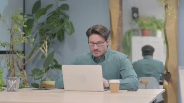 Thumbs Down by Middle Aged Businessman Working on Laptop