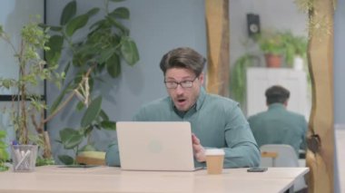 Middle Aged Businessman Reacting to Loss While Working at Work