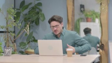 Middle Aged Businessman having Back Pain while using Laptop