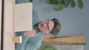 Vertical Video of Mature Adult Man having Wrist Pain while using Laptop