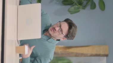Vertical Video of Mature Adult Man having Back Pain while using Laptop