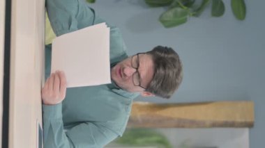 Vertical Video of Mature Adult Man Feeling Upset after Reading Documents, Paperwork
